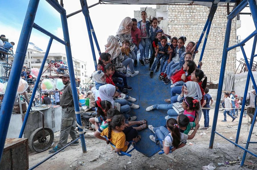 Syrian children play at a makeshift amusement park as they celebrate Eid Al Fitr in Syria's north-west city of Idlib.